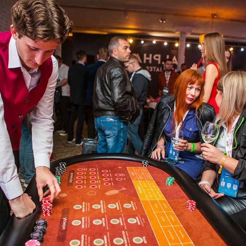 Invités participant à une activité d'équipe autour d'une table casino thématique